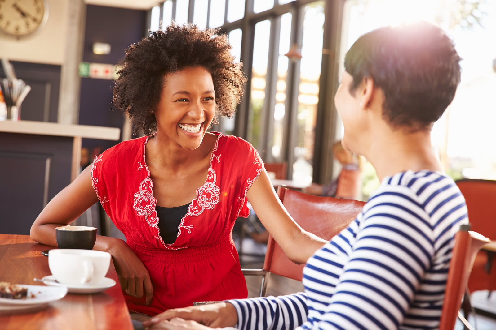 An owner has coffee with a customer on Get to Know Your Customers Day