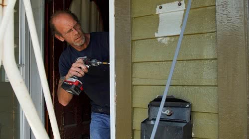 An employee repairs a residential home