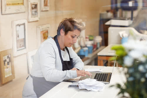 A female deli owner estimates her small business tax preparation cost 