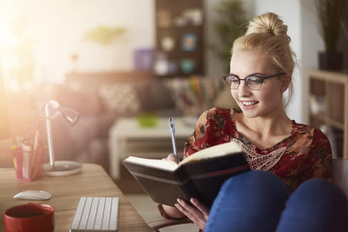 Small business owner arranging her schedule in a planner