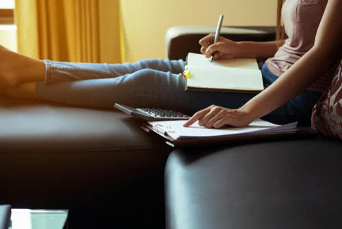 Woman small business owner does her taxes on the couch