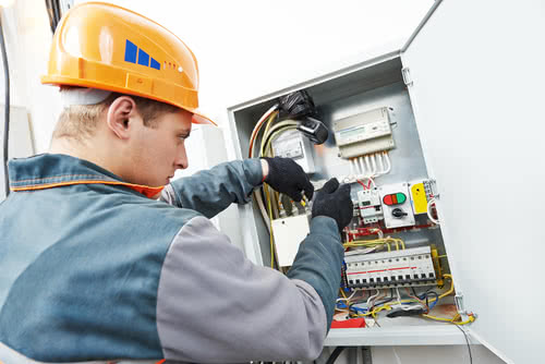 Business owner maintains safety while fixing fuse box, part of how to run a successful electrical business