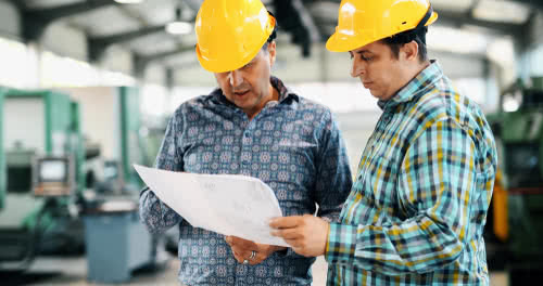 Business owners in a warehouse discuss collecting sales taxes from customers