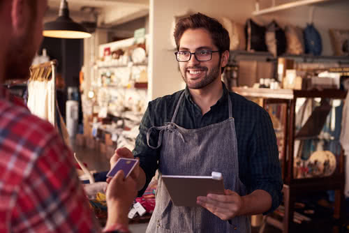 Online retail business owner processes a customer purchase on a tablet