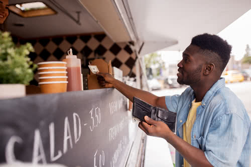 Man pays with cash at a food truck stand Man pays for food and wonders do businesses have to accept cash