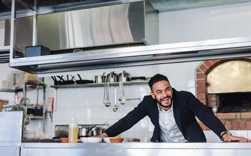 Owner standing in kitchen knows how to run a restaurant successfully