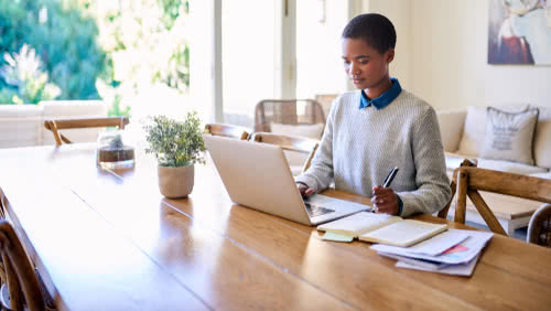 Female business owner calculates her negative cash flow in her home office