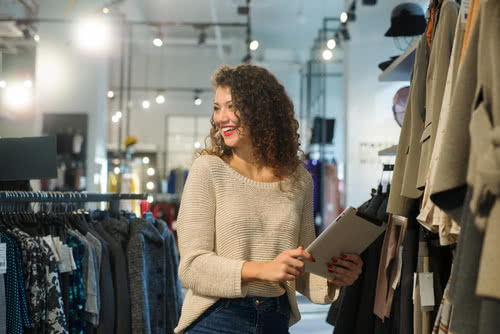 Small business owner uses a tablet in her boutique