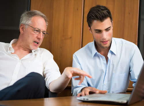 Father and son discuss how to transfer business ownership to a family member