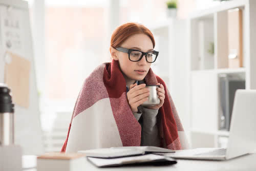 Female small business owner researches winter energy saving tips on her laptop