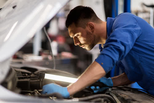 Auto mechanic follows government safety regulations for small business.