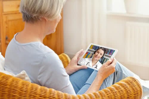 Doctor consults with elderly patient through telemedicine software