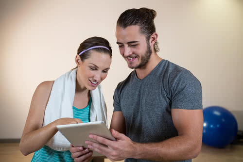 Reviewing gym business plan with fitness trainer