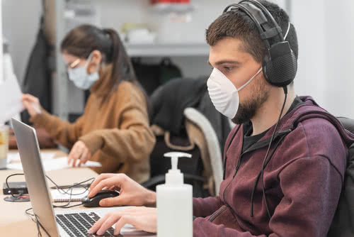 Coronavirus. Business workers working from home wearing protective mask. Small company in quarantine for coronavirus working from home with sanitizer gel. Small company concept.