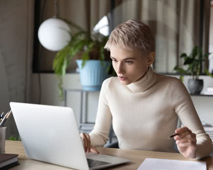 Serious focused businesswoman working on research sit at desk use laptop read e-mail working in office. Lawyer prepare legal agreement for client, secretary organize work having busy workday concept
