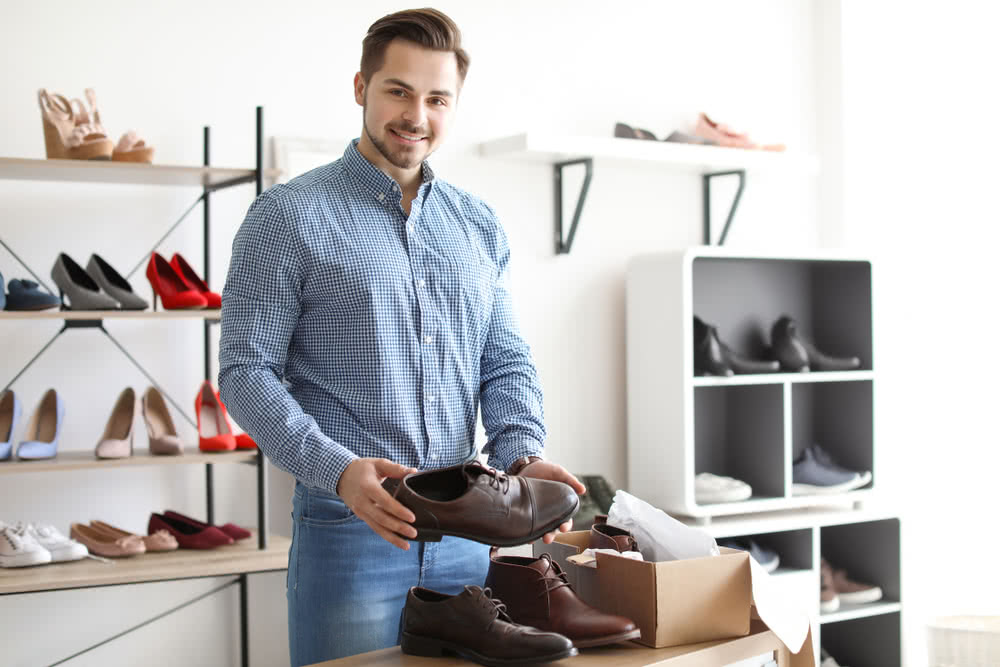 Young man choosing shoes in store - net income vs. net revenue