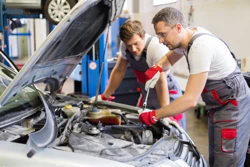 Two mechanic fixing car in a workshop